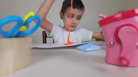 A child is actively engaging in creative play while using an array of colorful Stock Footage 301439235