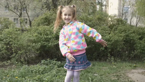 The child is actively playing and moving fun. Little schoolgirl dances outdoo Video stock 107081269