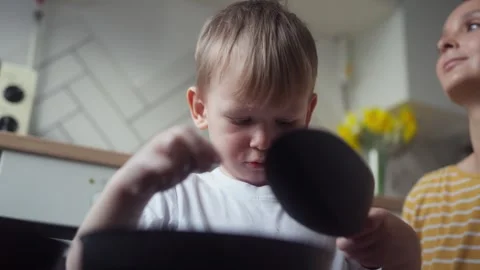 Child adding drainage material or expanded clay to pot before planting seedlings Stock Footage 331439560