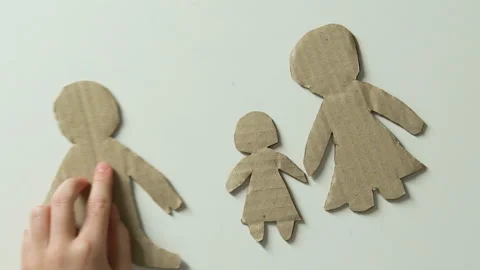 Child adding figure of father and toy heart to paper family lack of fathers love Stock Footage 101585112