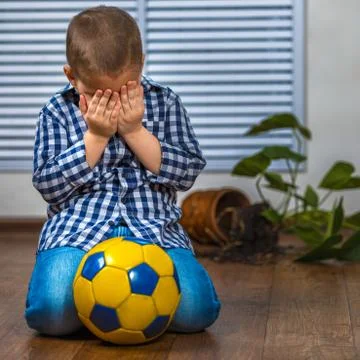 The child is afraid of punishment. He smashed the flower pot Stock Photos