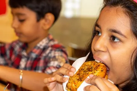 Child (age- 10) eats fast food. Fast food is highly processed Stock Photos