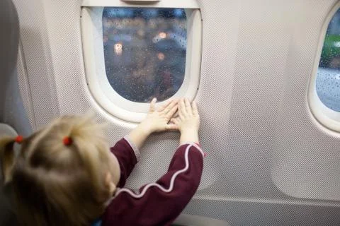Child in airplane looking at the window Stock Photos