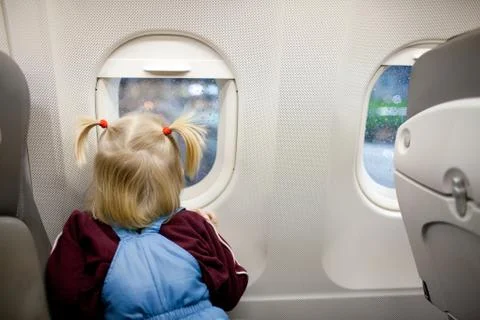 Child in the airplane looking at the window Stock Photos