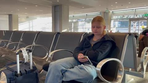 Child at the airport using cellphone Stock Footage 293003538