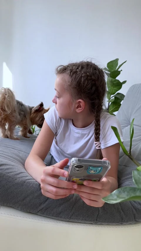 Child and gadget concept, using phone apps looking at mobile device while Stock Footage 238598000