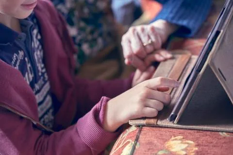 Child and his grandmother using a tablet Stock Photos