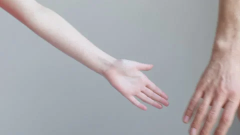 A child and a man join hands and hold against the background of a white wall Stock Footage 170544737