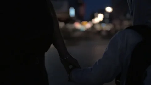 Child and mother holding hands while walking at night Stock Footage