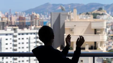 Child applauding medical staff from their balcony. People in Spain clapping g Stock Photos