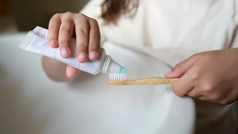 Child applying toothpaste to bamboo toothbrush. Stock Footage 313102498