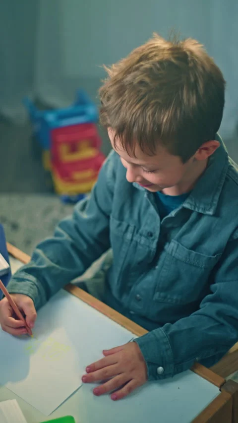Child Artistic Development Little Boy Creating Artwork with Pencils in His Room Stock Footage 284350550