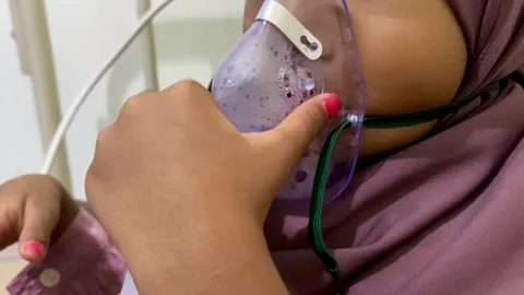 A child with asthma is being treated with a nebulizer at the hospital Stock Footage 291225749