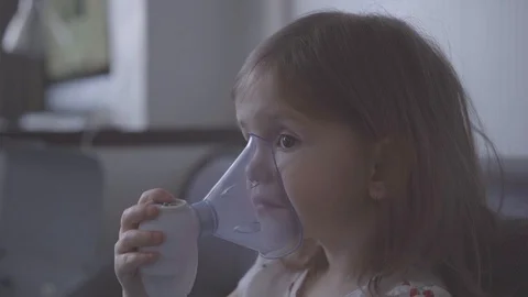 Child with asthma problems making inhalation with mask on face Stock Footage 127564417