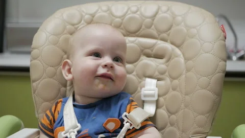 The child ate half a year and sat contentedly in the child seat. Stock Footage 108375488