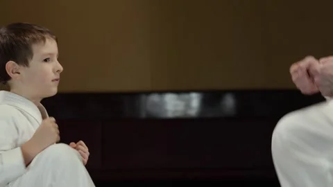 A child athlete does an exercise raising legs to arms together with a trainer Stock Footage 301507320