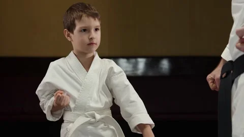 A child athlete performs blocks with his hands against a kick with his coach Stock Footage 301506817