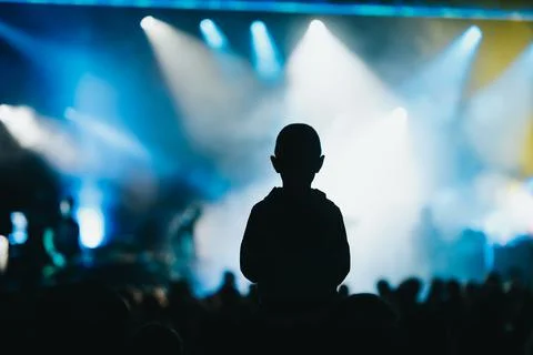 Child in a audience crowd having fun and enjoying concert on a festival Stock Photos