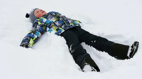 Child, baby boy plays with snow in winter outdoors. Video stock 59182581