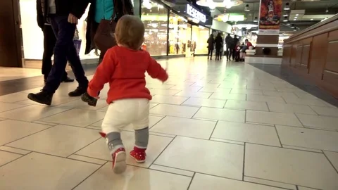 Child Baby run and fall down through the Mall and Clothes Store Stock Footage