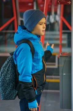 Child with Backpack Standing Inside Train Holding Handrail on Public Transpor Stock Photos