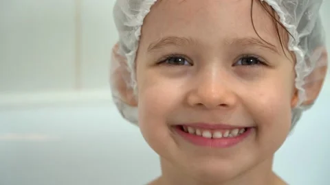 Child bathes with soap bubbles in white bathroom. Girl smiles and laughs Stock Footage 153077991