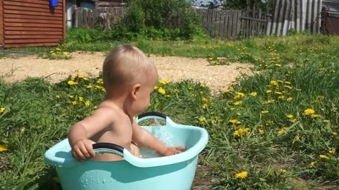 The child bathing in a basin of water. summer. Sunny day. Stock Footage 85000997