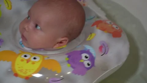 A child is bathing in a bathtub with an inflatable circle. Video stock 160194426