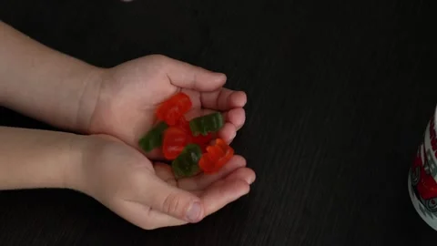 A child is being given gummy bear candy to fill his hands Stock Footage 317918228