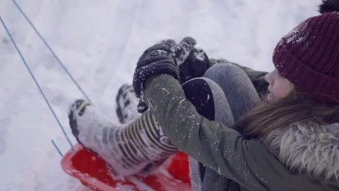 Child being pulled along on a snow sledge Stock Footage 86748106