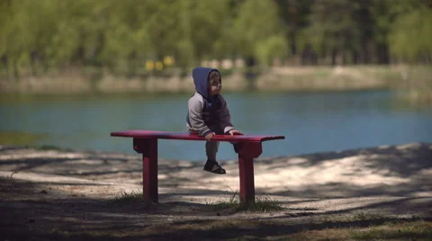 Child on the bench by the lake Stock Footage 62734295