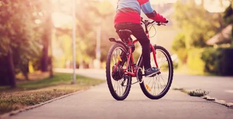 Child on a bicycle in the evening Stock Photos