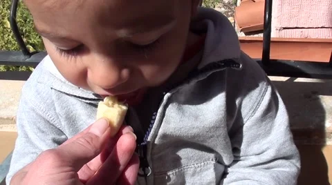 Child bites and spits out a piece of given banana Video stock 49121077