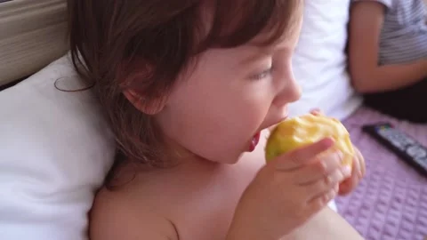A child bites an apple. Close-up of the face of a child who eats fruit. Video stock 162874275