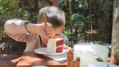 Child biting strawberry cake in restaurant. Stock Footage 266870557