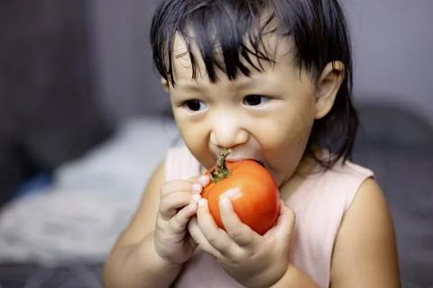 Child Biting Tomato Stock Photos
