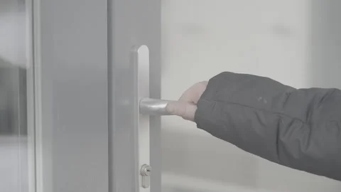 A child in a black jacket opens the handle of a glass door. Slog-3 Vidéo 307490697
