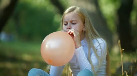 Child Blowing Up a Balloon Vídeo Stock 12416758