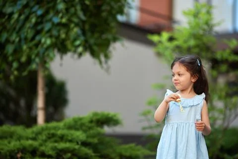 Child blowing soap bubbles in backyard garden Stock Photos