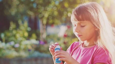 Child is blowing soap bubbles in sunny green outdoors. Slow Motion 240 fps. Vidéo 55704708