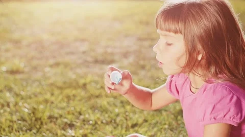 Child is blowing soap bubbles in sunny green outdoors. Slow Motion 240 fps. Vidéo 55707223
