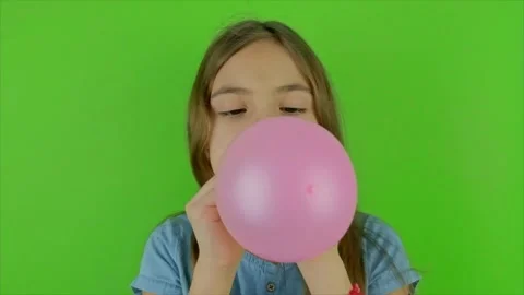 A child blows a balloon on a green background. Selective focus. Video stock 169605697