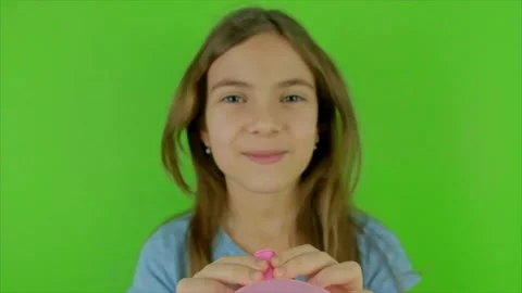 A child blows a balloon on a green background. Selective focus. Video stock 169693614