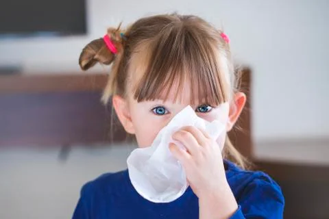 Child blows her nose into a handkerchief. Stock Photos