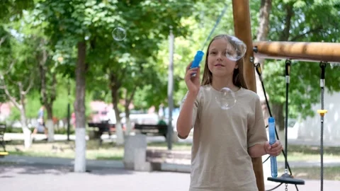 A child blows soap bubbles in the park. Stock Footage 302800218