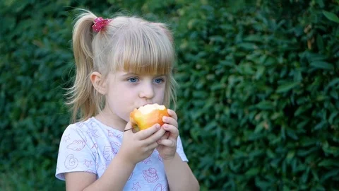 A child with blue eyes eats Apple Video stock 95598466