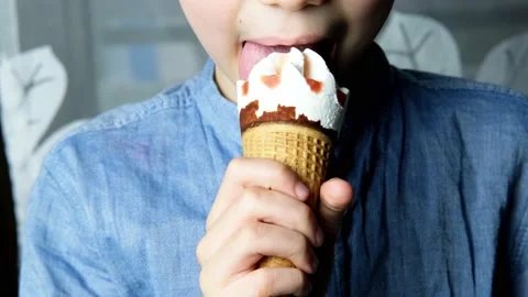 Child, a boy of 7 years old holds a waffle cone with delicious popsicles in h Video stock 152602301