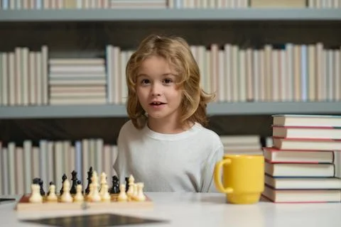 Child boy developing chess strategy, playing board game. Intelligent and smart Foto stock