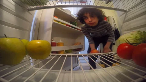 Child Boy Eating Fruit from the Fridge Stock Footage