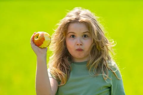 The child boy eats an apple. Ripe fruit for kids. Child bites apple. The child Stock Photos